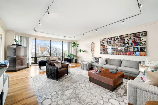 a living room with furniture large window and flat screen tv