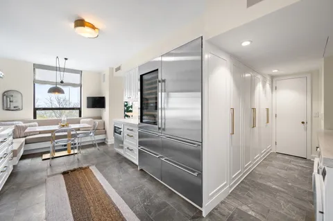 a kitchen with stainless steel appliances kitchen island granite countertop a refrigerator and a sink