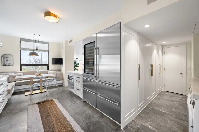 a kitchen with stainless steel appliances kitchen island granite countertop a refrigerator and a sink