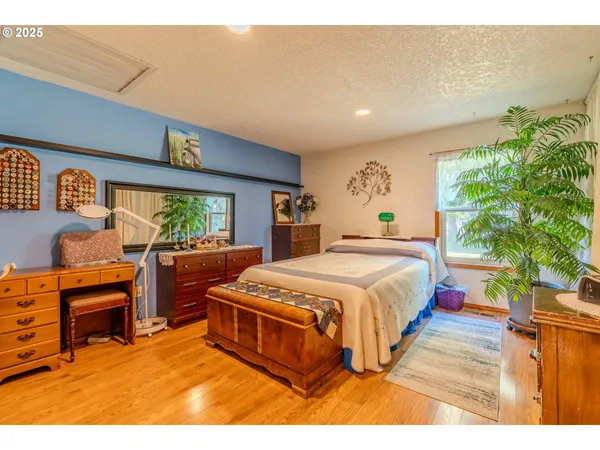 a spacious bedroom with a bed and a flat screen tv