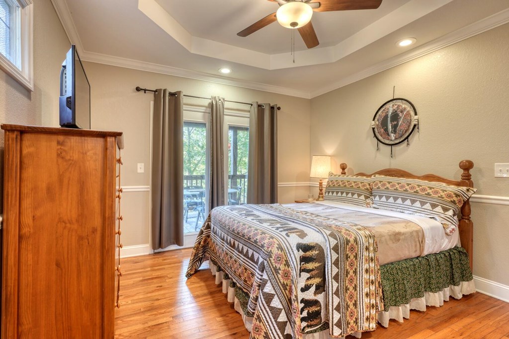3204 Creekview Road Hiawassee, GA 30546 - Photo 13 of 45 a bedroom with a large bed and a chandelier