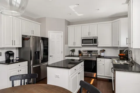 a kitchen with white cabinets and stainless steel appliances