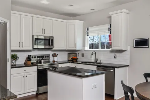 a kitchen with stainless steel appliances a sink a stove and a microwave