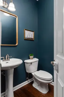 a bathroom with a toilet a sink and mirror