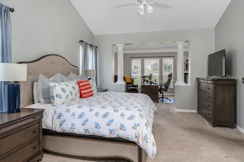 a bedroom with a bed and a flat tv screen on dresser