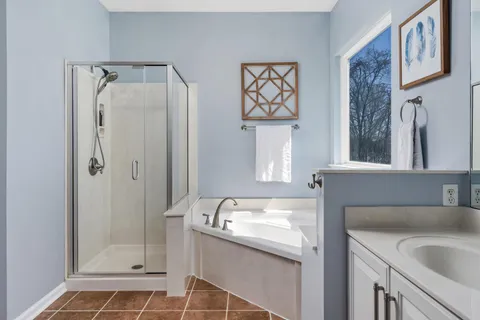 a bathroom with a granite countertop sink a mirror and shower