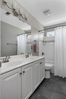 a bathroom with a toilet a sink and mirror
