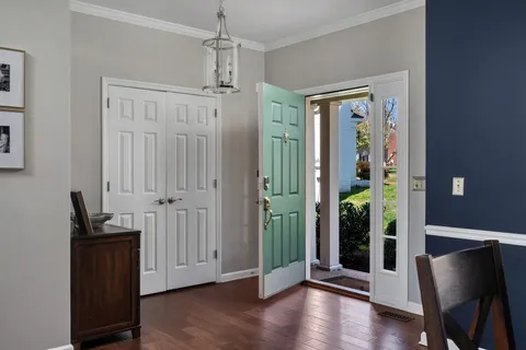 a view of a hallway with wooden floor and glass door