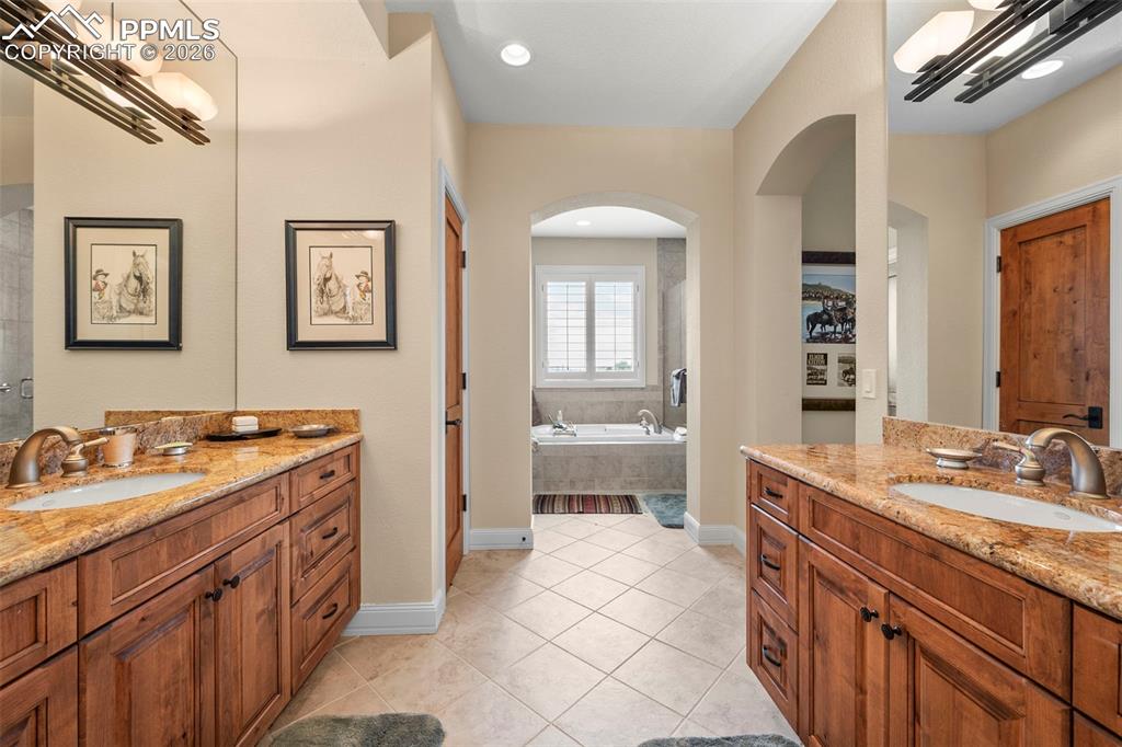 4025 Reserve Point Colorado Springs, CO 80904 - Photo 38 of 50 a spacious bathroom with a granite countertop sink and a mirror