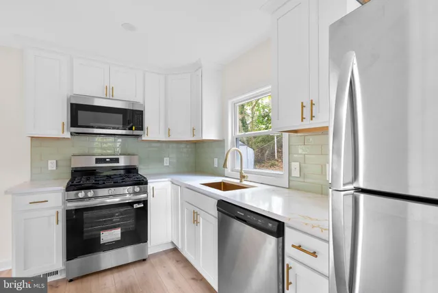 a kitchen with stainless steel appliances a stove a sink and a microwave