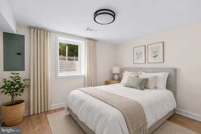 a bedroom with a bed and a potted plant