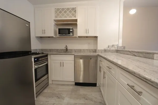 a kitchen with stainless steel appliances granite countertop a sink stove and microwave