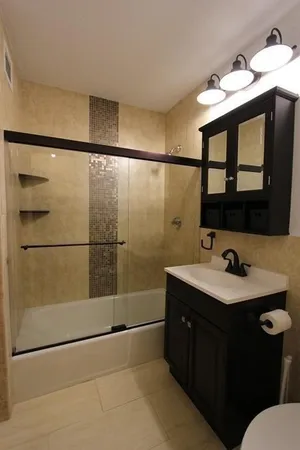 a bathroom with a sink toilet a mirror and shower