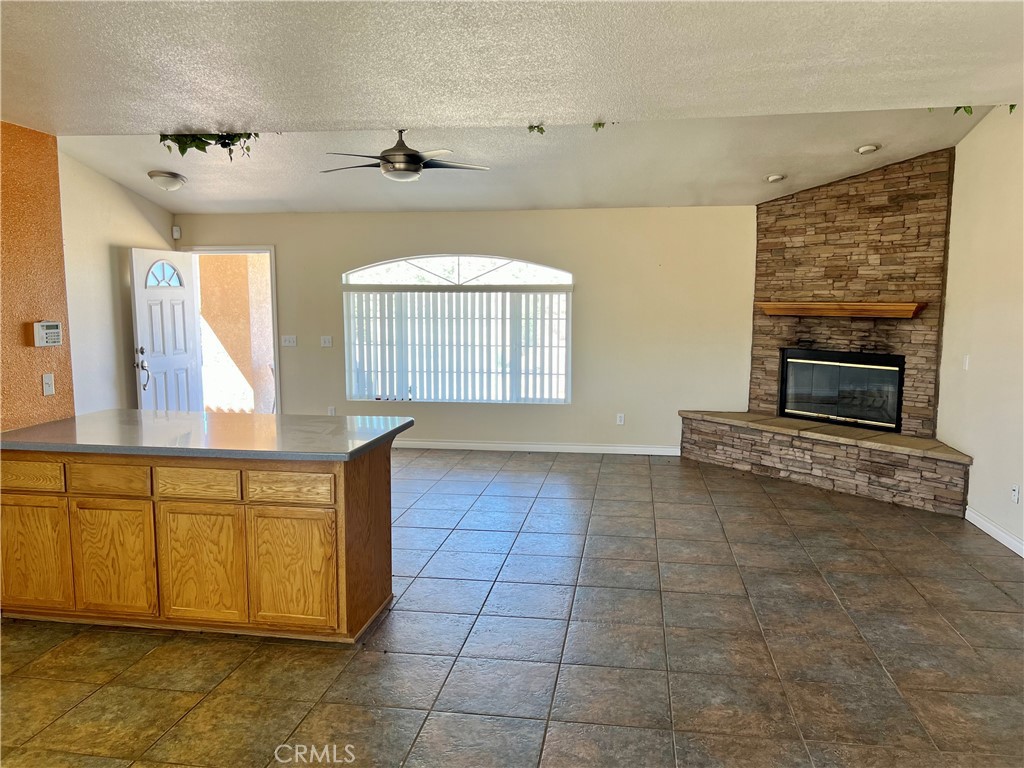 25625 Rancho Street Apple Valley, CA 92308 - Photo 5 of 18 a view of an empty room with a fireplace and a window