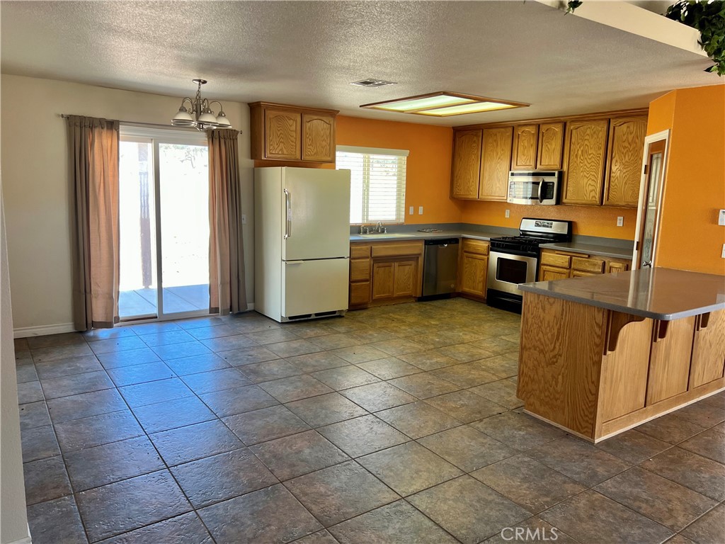 25625 Rancho Street Apple Valley, CA 92308 - Photo 6 of 18 a kitchen with stainless steel appliances granite countertop a refrigerator and a stove