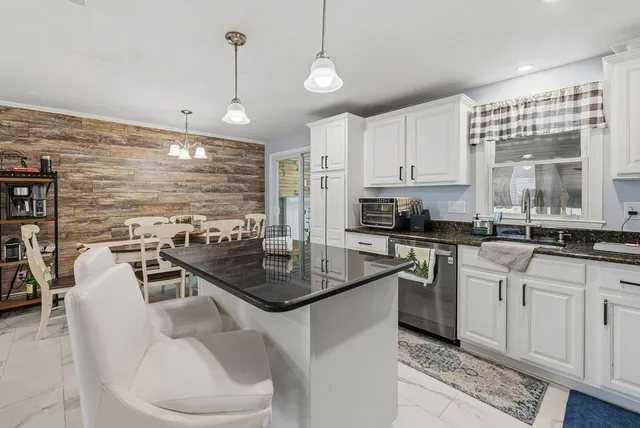 a kitchen with stainless steel appliances granite countertop a sink a stove and a wooden cabinets