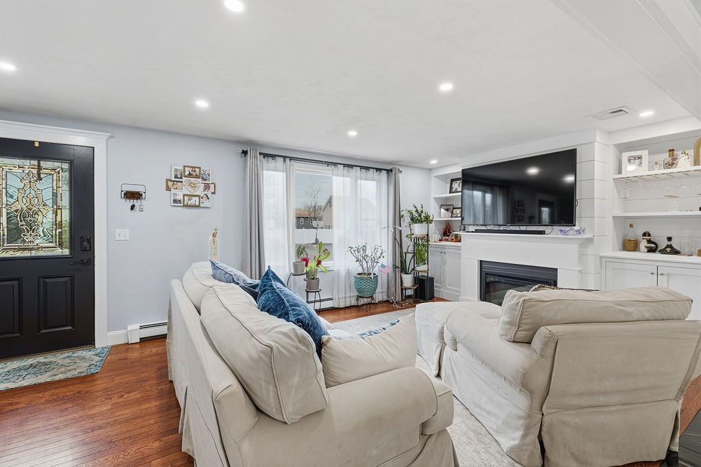 16 Perry Avenue, Unit 16 Taunton, MA 02780 - Photo 19 of 40 a living room with furniture a fireplace a flat screen tv and view kitchen
