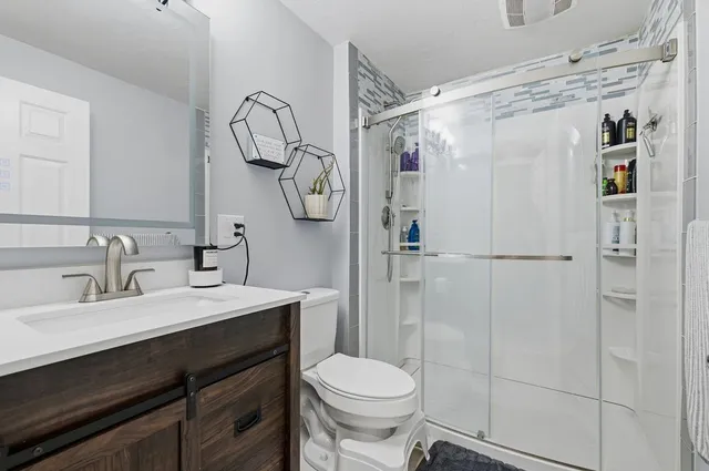 a bathroom with a sink vanity mirror and toilet