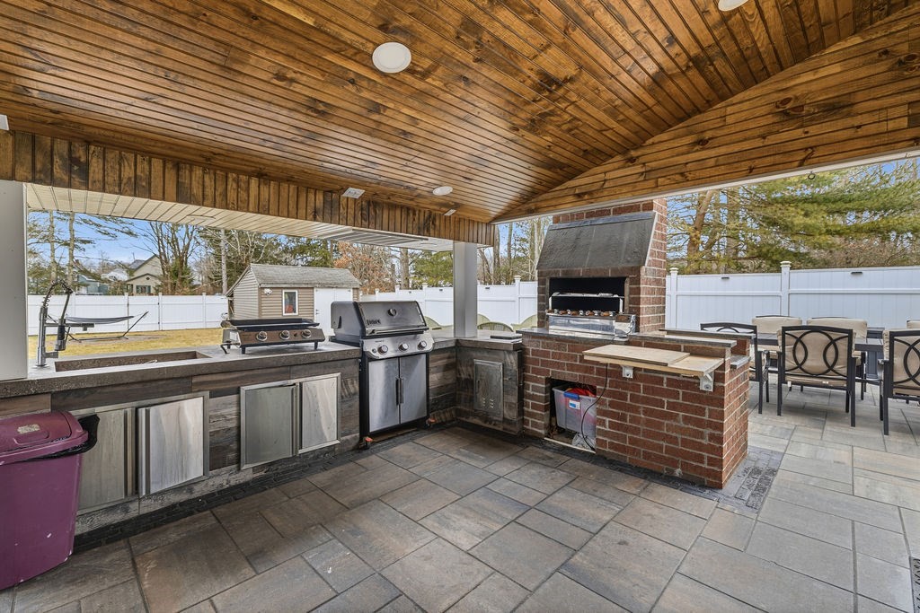 16 Perry Avenue, Unit 16 Taunton, MA 02780 - Photo 29 of 40 a kitchen with stainless steel appliances wooden cabinets table and chairs