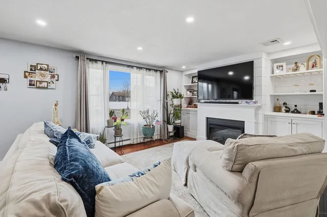 a living room with furniture a flat screen tv and a fireplace