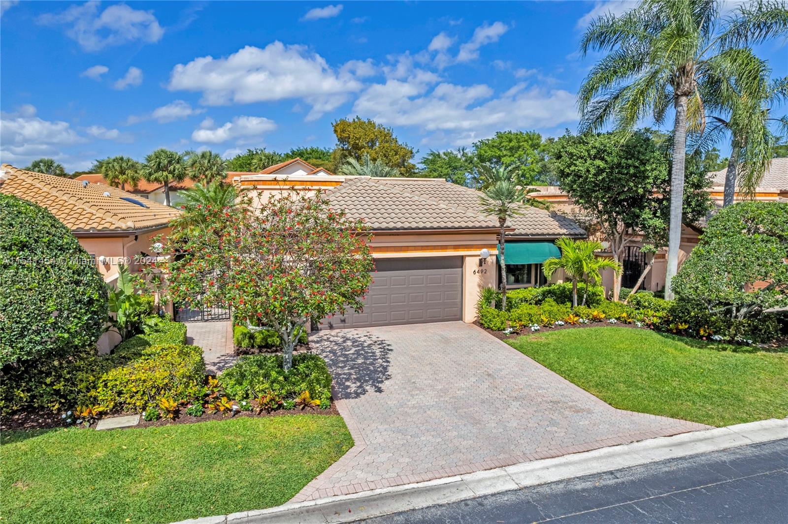 6492 Via Rosa Boca Raton, FL 33433 - Photo 63 of 66 a front view of a house with a yard and potted plants