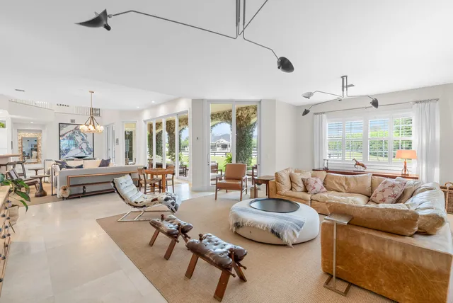 a front view of a house with a yard and potted plants