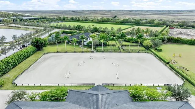 an aerial view of residential house with outdoor space and trees all around