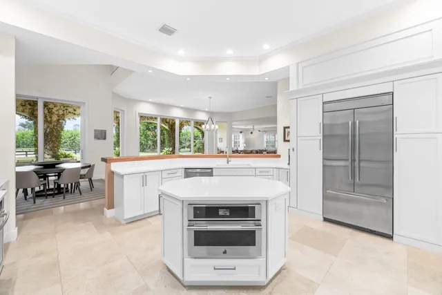 a dining room with furniture large windows and wooden floor