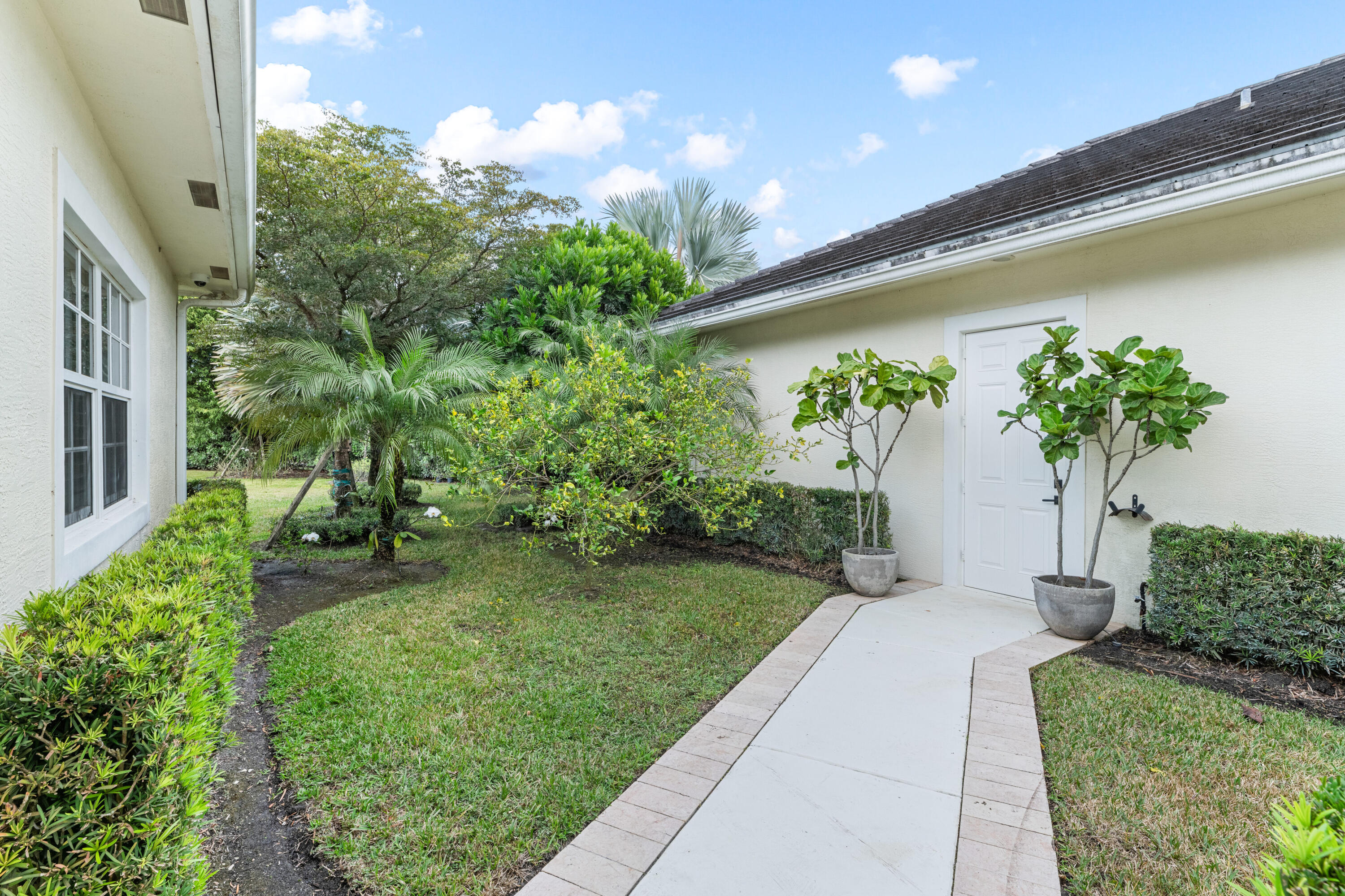 14739 Jumper Road Wellington, FL 33449 - Photo 67 of 124 a front view of a house with a yard and potted plants