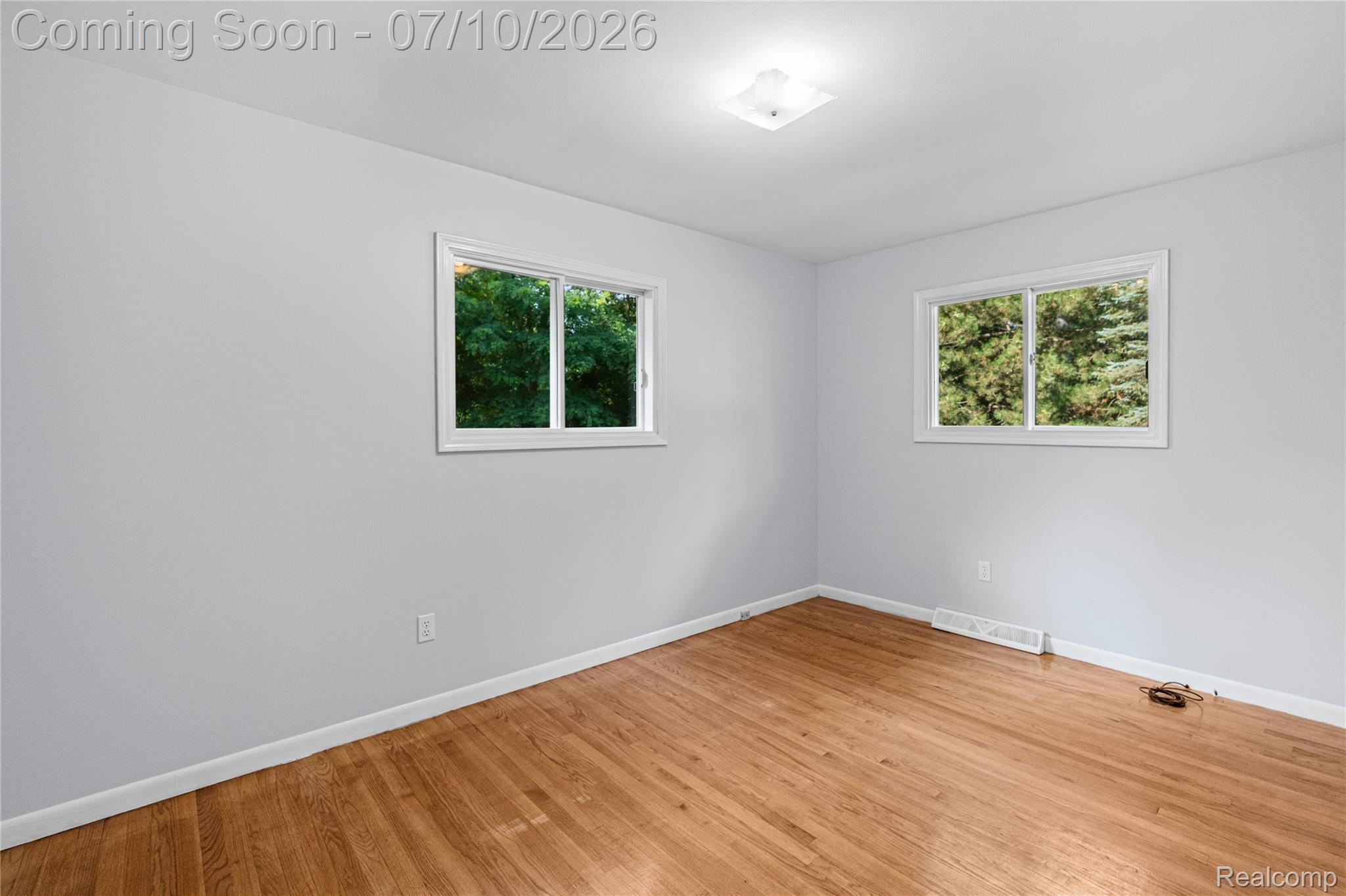 1715 North Oxford Road Oxford, MI 48371 - Photo 14 of 29 Light-filled room featuring hardwood flooring and two white-framed windows