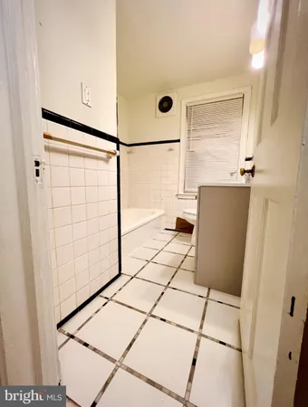 a view of a refrigerator in kitchen and an empty room
