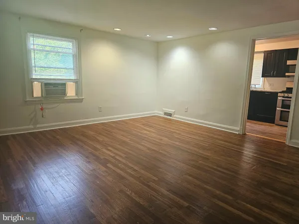 an empty room with wooden floor and a window