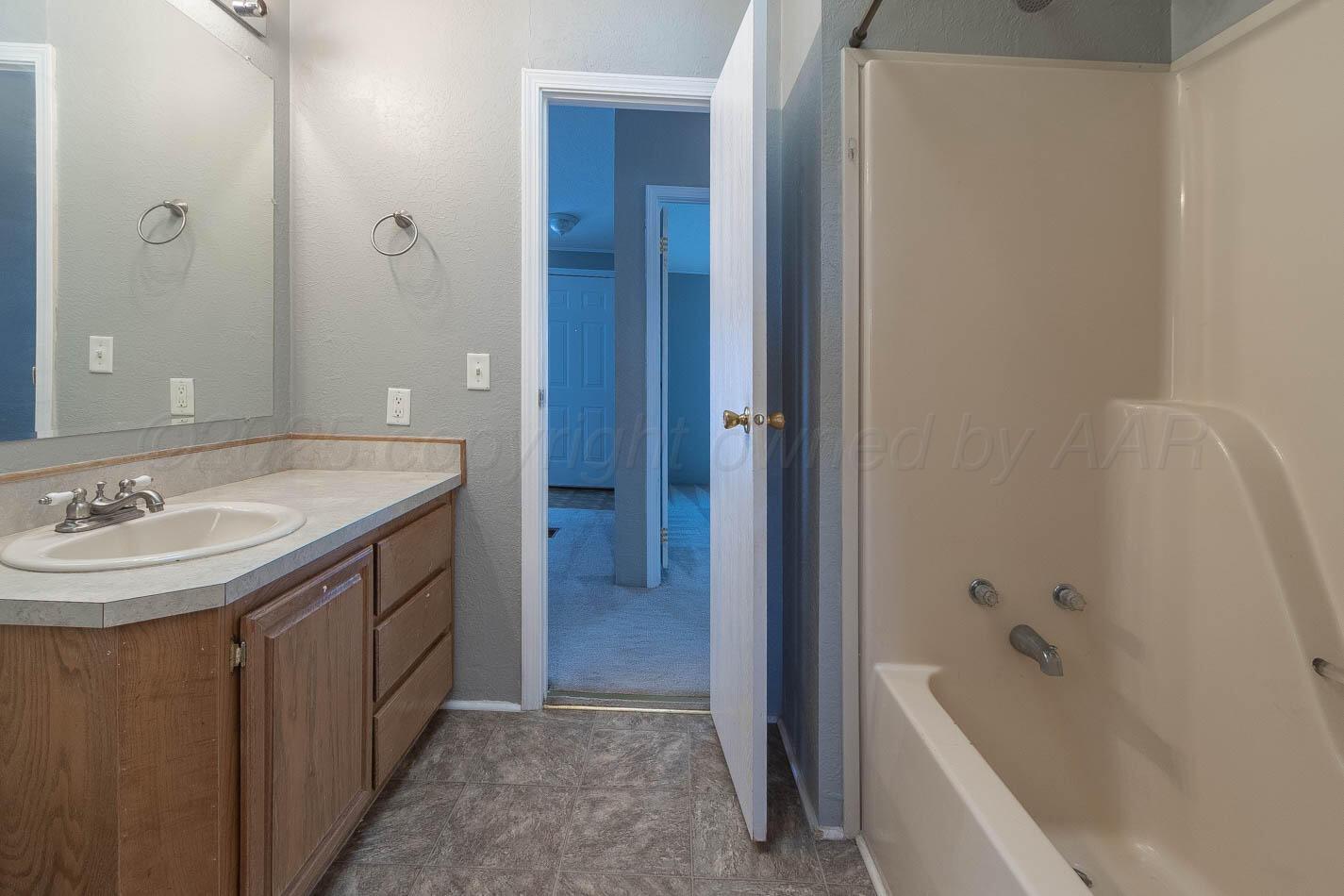 5606 West McCormick Road Amarillo, TX 79118 - Photo 14 of 23 a bathroom with a sink and a bathtub