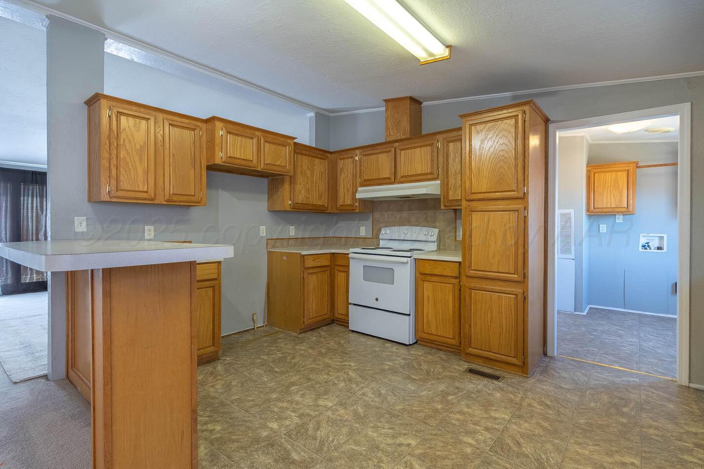 5606 West McCormick Road Amarillo, TX 79118 - Photo 8 of 23 a kitchen with a sink refrigerator and cabinets