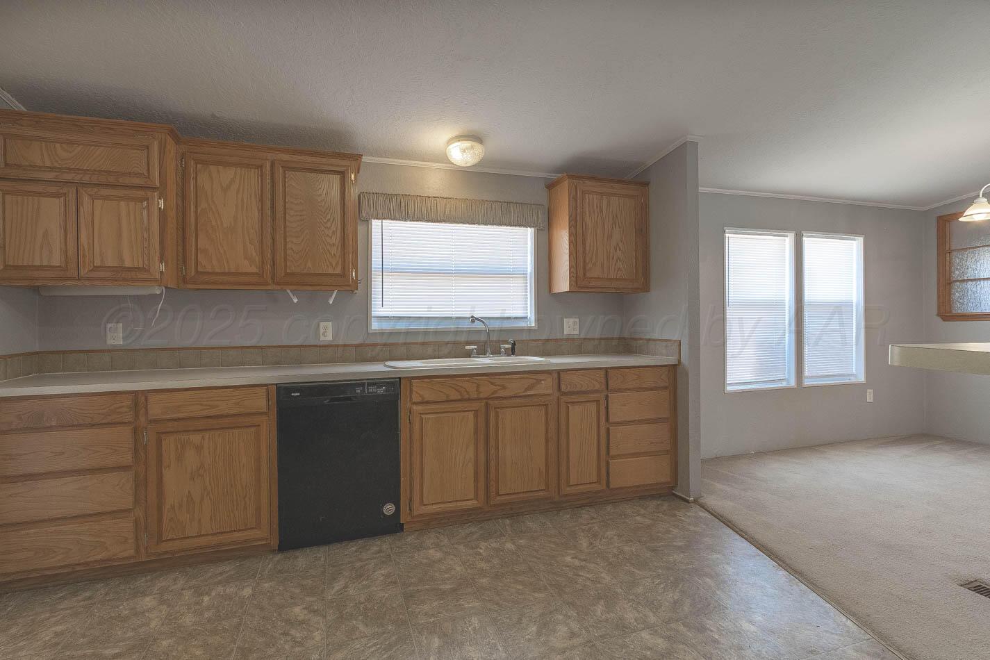 5606 West McCormick Road Amarillo, TX 79118 - Photo 9 of 23 a kitchen with granite countertop a sink and cabinets