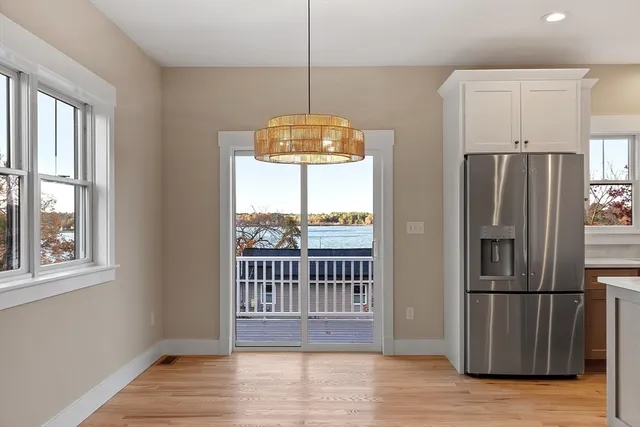 a kitchen with a refrigerator a sink and wooden floor