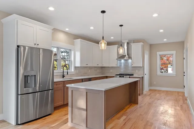 a large kitchen with granite countertop a sink counter space and stainless steel appliances
