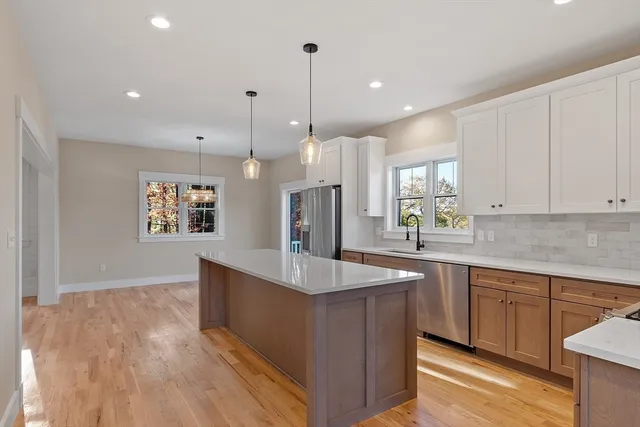 a kitchen with stainless steel appliances granite countertop a sink a stove and a wooden floors