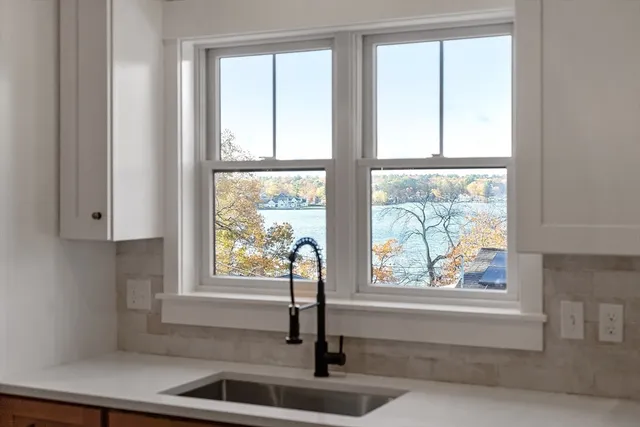 a large kitchen with kitchen island a stove a sink a refrigerator and a wooden floor