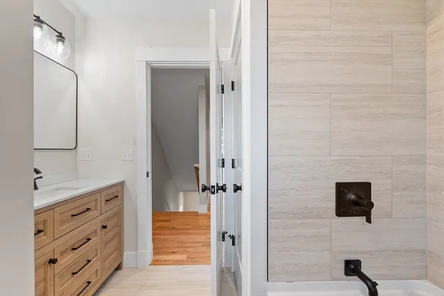 a view of a hallway with wooden floor and staircase