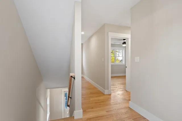a view of an empty room with window and wooden floor