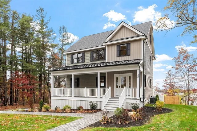 an aerial view of ocean and residential houses with outdoor space