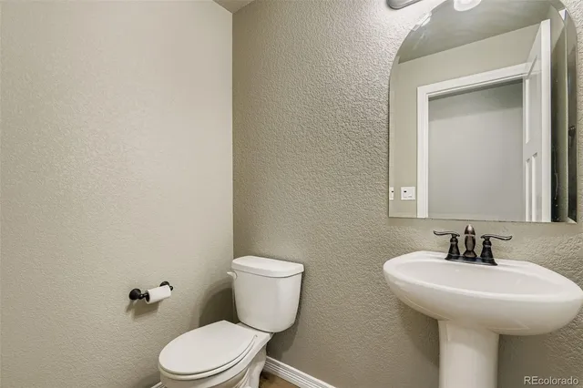a bathroom with a toilet a sink and mirror