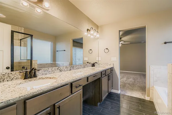 a bathroom with a granite countertop double vanity sink and a mirror