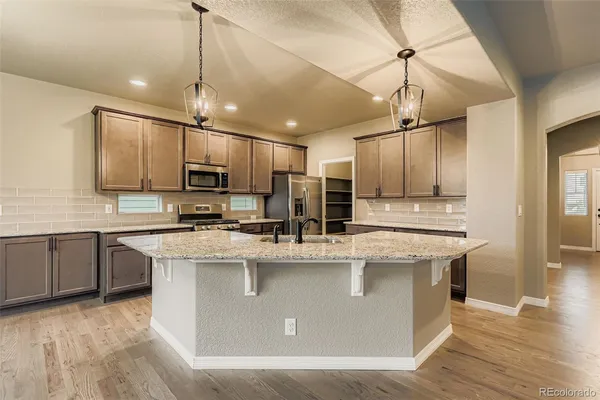 a kitchen with kitchen island a sink counter top space cabinets and stainless steel appliances