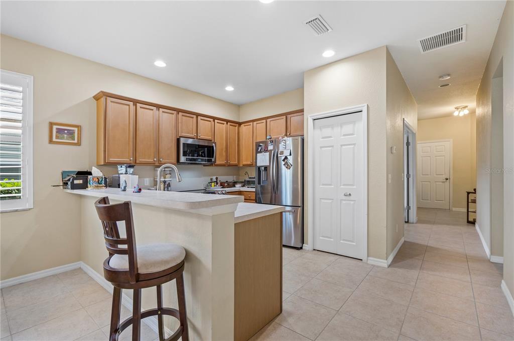 11815 Tempest Harbor Loop Venice, FL 34292 - Photo 9 of 63 a kitchen with kitchen island a refrigerator stove microwave and cabinets