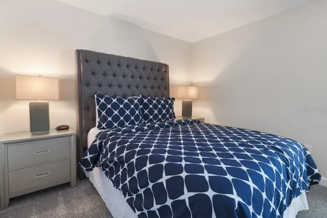 a large bed sitting in a bedroom next to a lamp