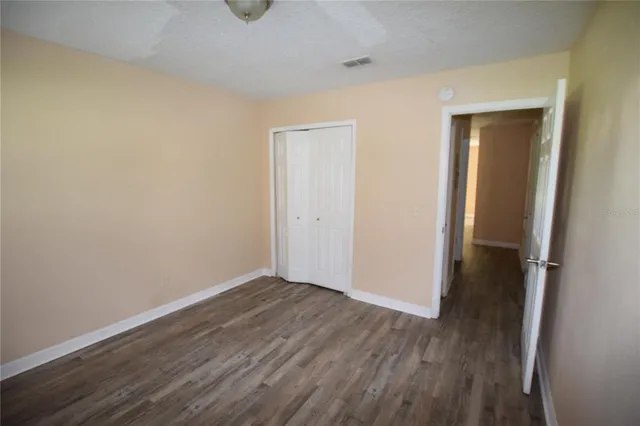 an empty room with wooden floor and closet