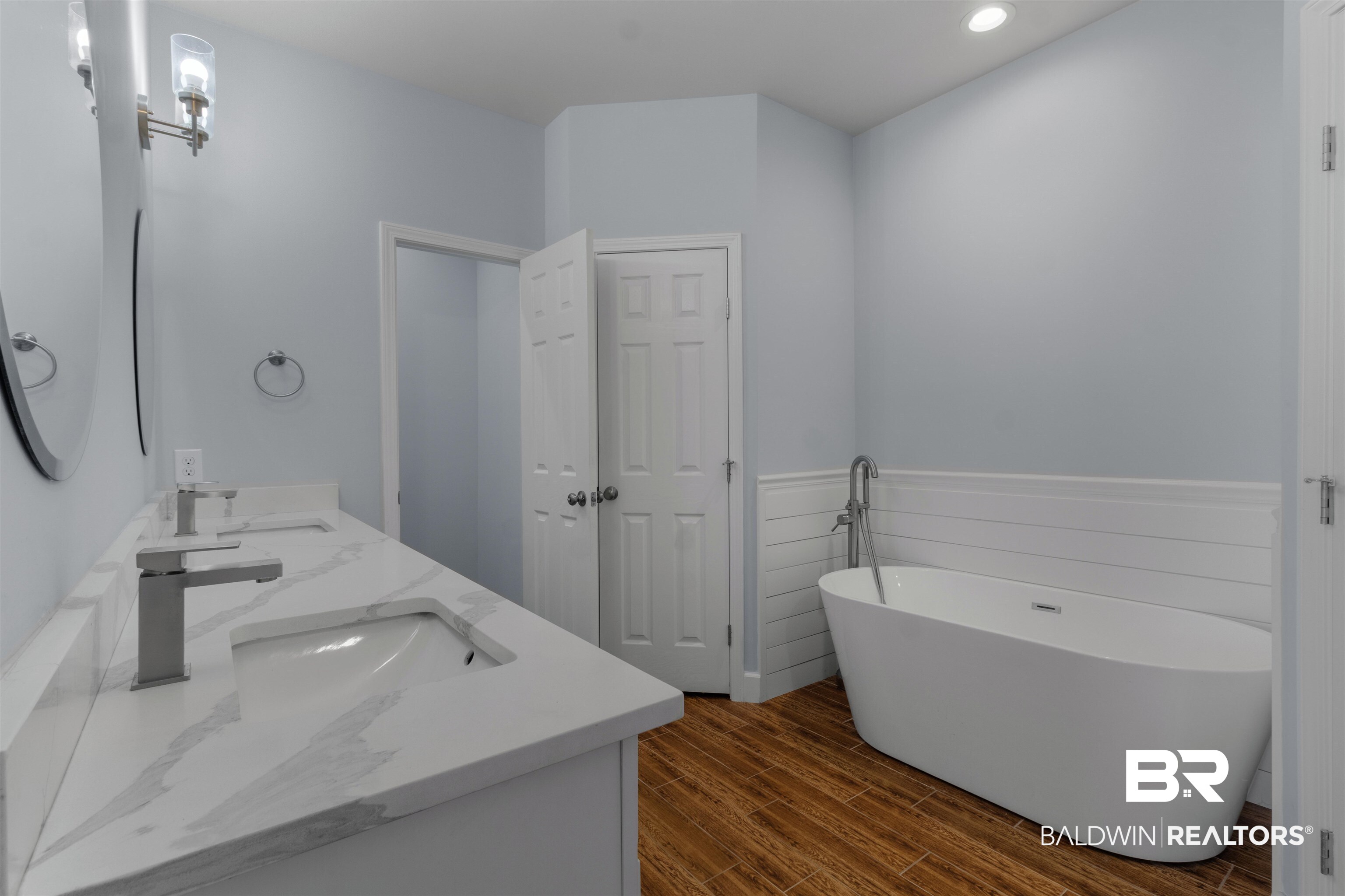 927 Periwinkle Lane Foley, AL 36535 - Photo 8 of 26 Bathroom featuring a freestanding tub with floor-mounted faucet, shiplap wainscoting, and wood-finish flooring