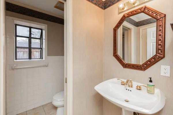a bathroom with a toilet sink and mirror